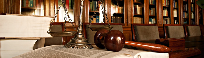 Desk in library with law book and gavel.