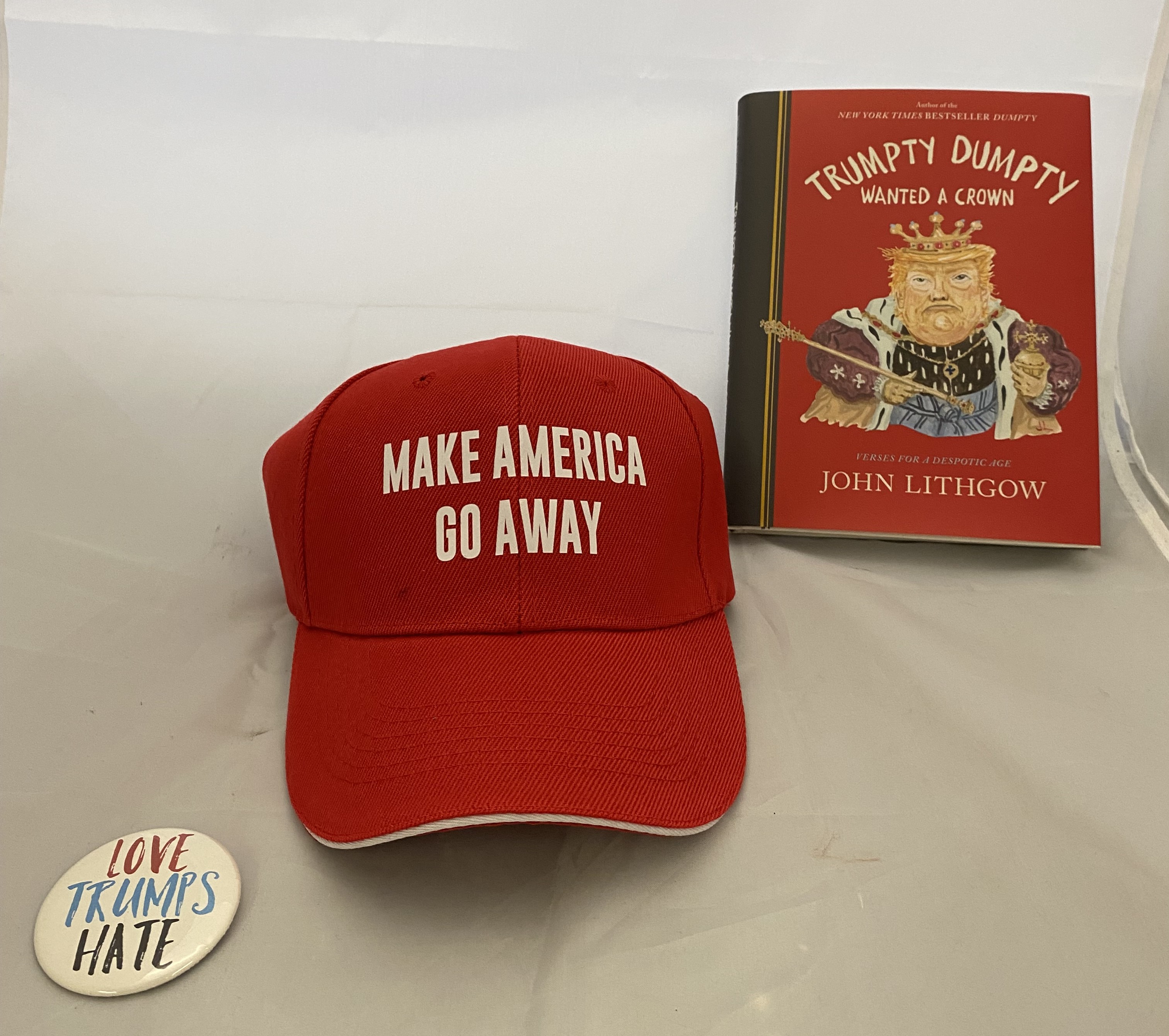 A book, a red cap, and white badge